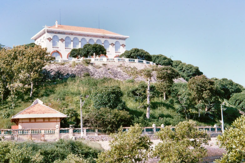 a house sitting on top of a hill on a sunny day