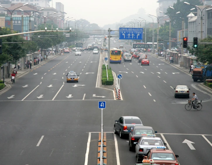 traffic on a road in a city near many trees