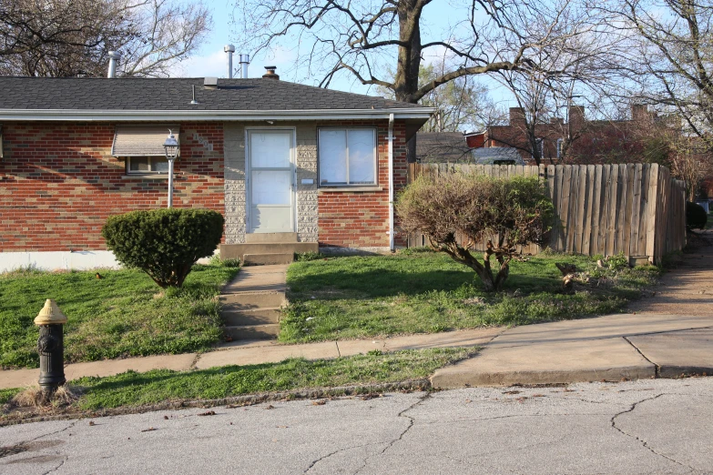 an older red brick house and a yard