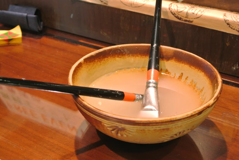 a pair of black chop sticks sticking out of a cup