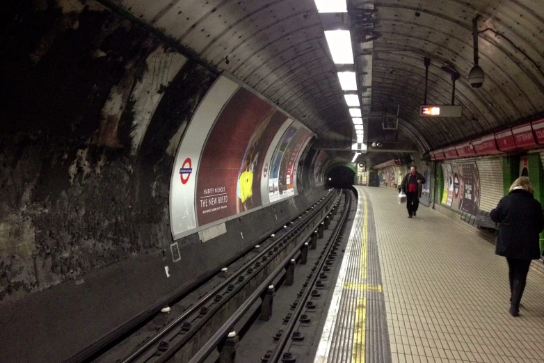 people walk through the train station with subway tracks