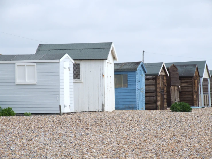 an assortment of buildings sit in a gravel area