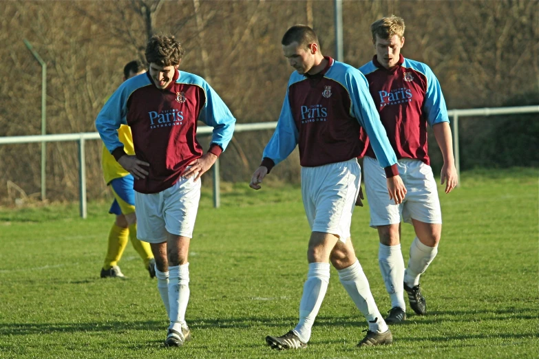 two men are standing on a field playing soccer