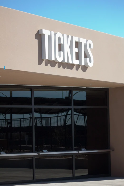 the entrance to a store called tickets on a bright day