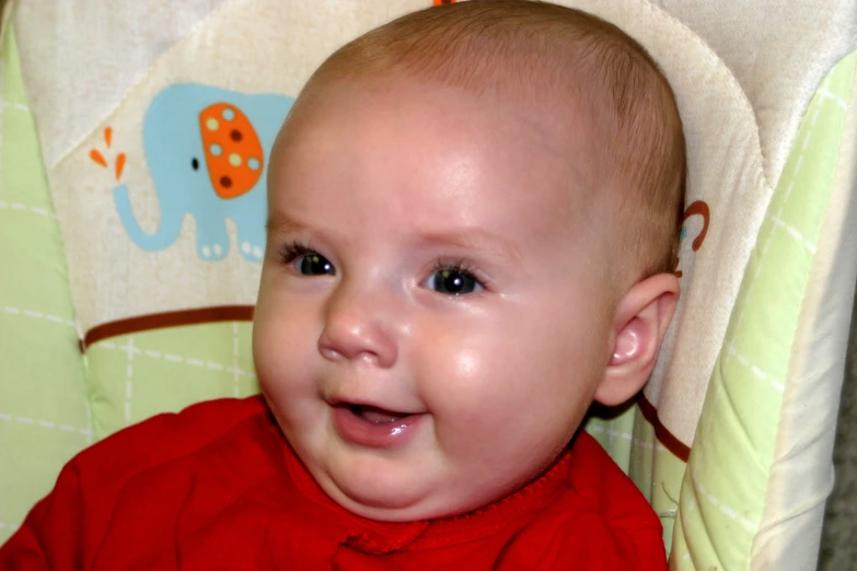 a close up of a baby in a child's high chair