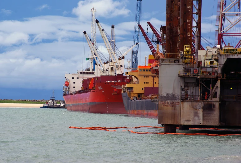 the large red ship is floating near shore