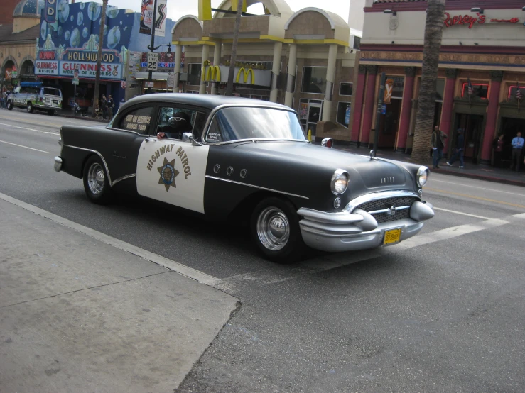 a classic police car drives down the street