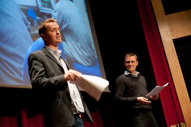 the young men are standing on stage and playing games