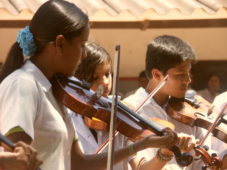 children with instruments in uniform during an outdoor concert