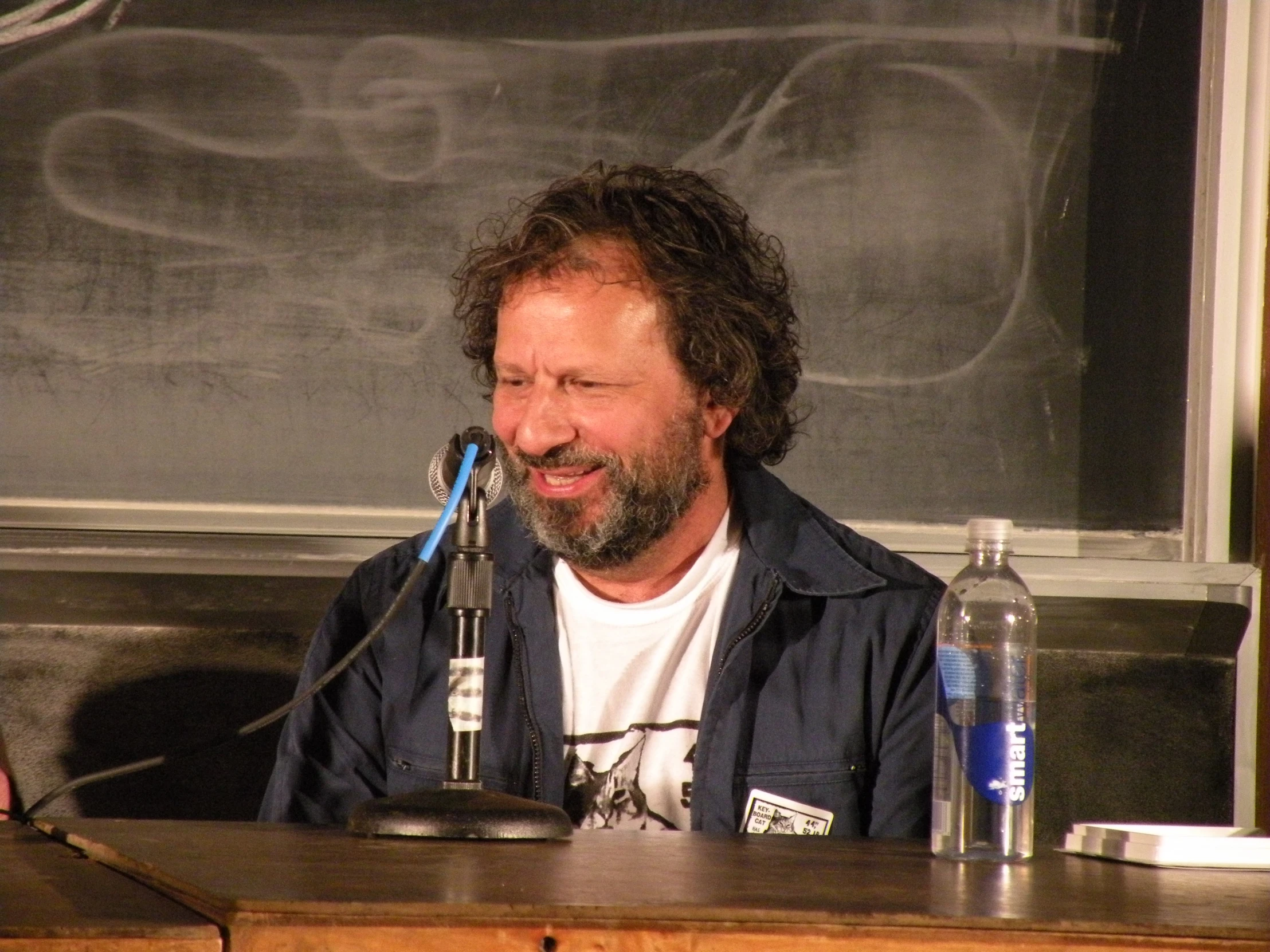 a man sitting at a desk with a microphone in front of him