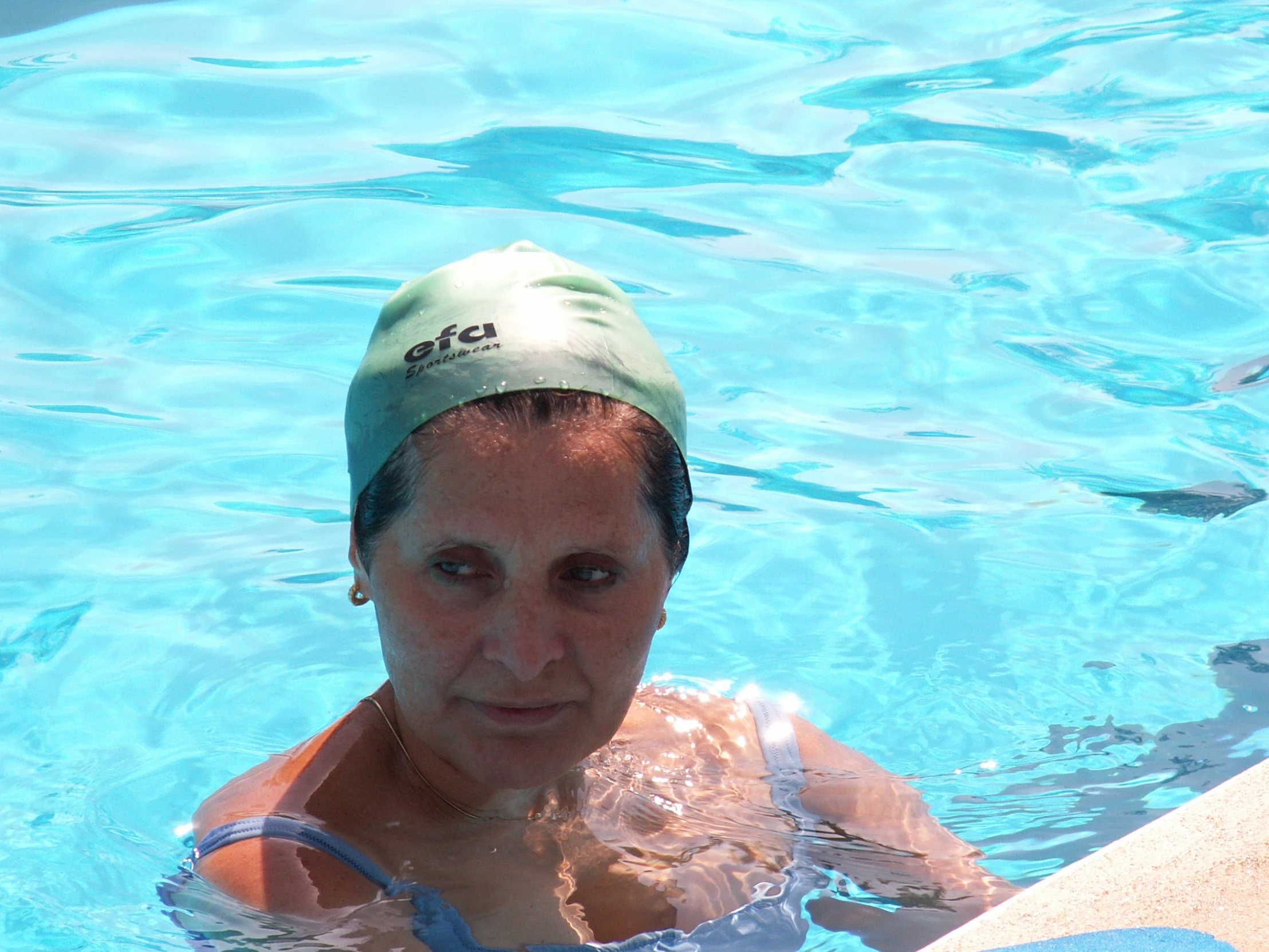 a woman in the water with a green hat