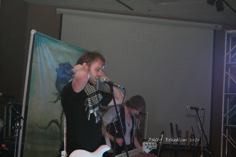 a man with a white guitar and microphone