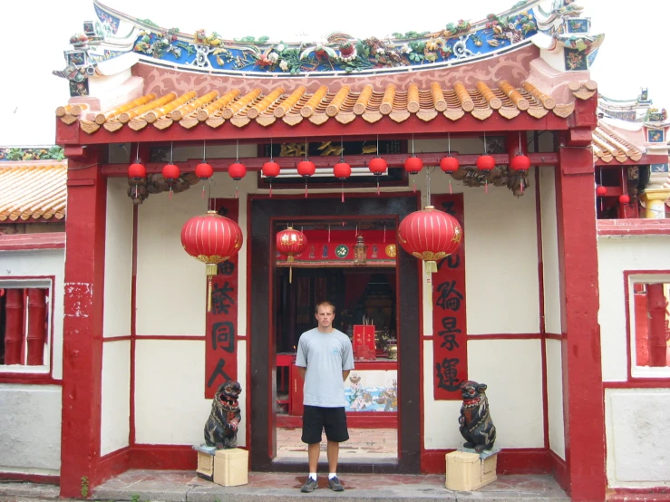 a man standing at the entrance of a chinese temple