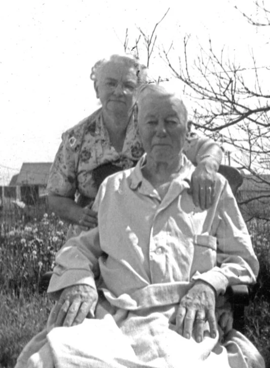 an old woman is sitting with an elderly man