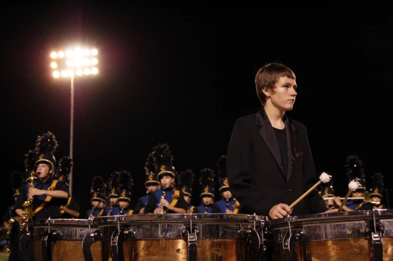 the boy with the marching band is playing for his team