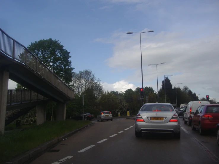 cars traveling down a street at an intersection with a traffic light