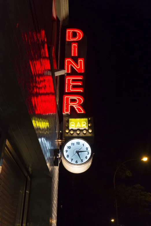 the bright neon sign reads diner on a dark night