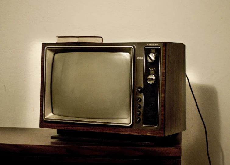 an old tv sitting on top of a wooden stand