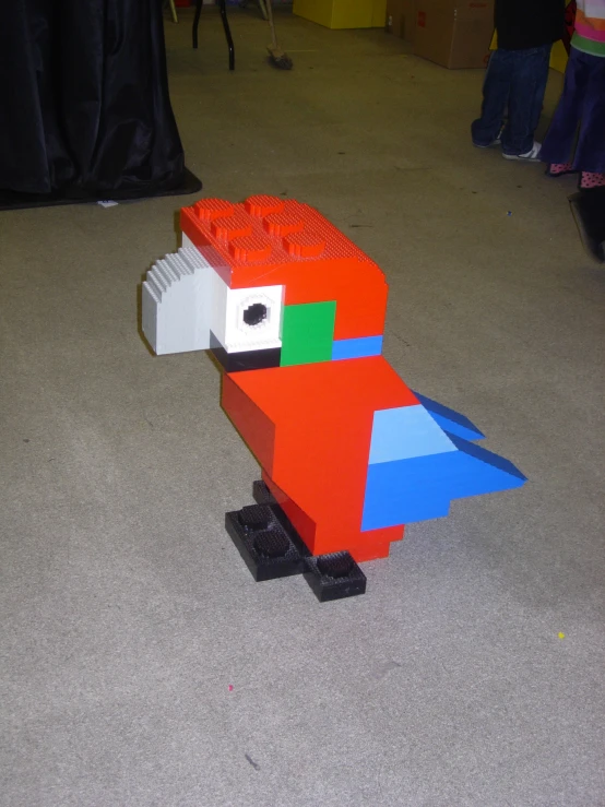 a very cute lego bird standing on the floor