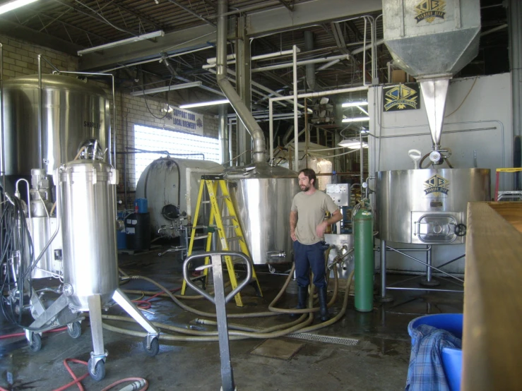 a man standing near some steel tanks