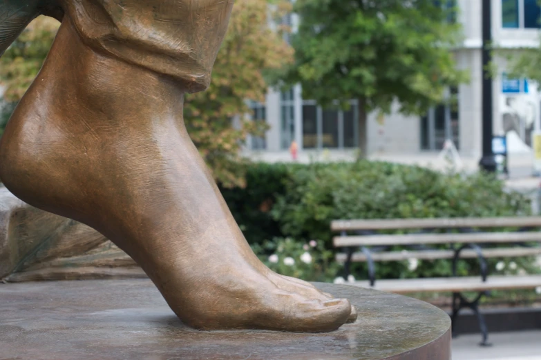 a statue of a bare foot on a bench