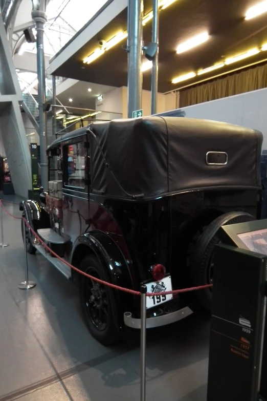 an antique car on display with people around it