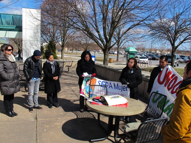 people standing around and holding up signs on the sidewalk