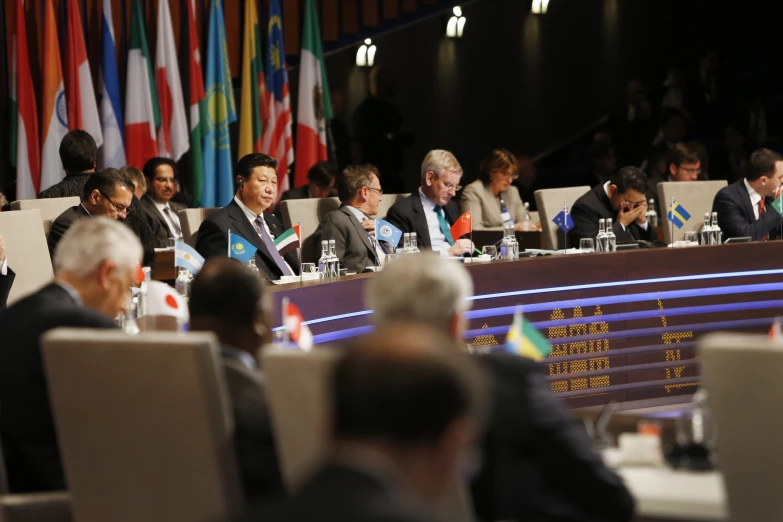 people sit at tables in chairs with flags around them