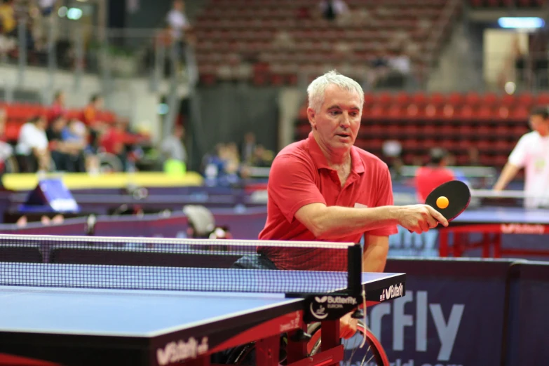 an older man is playing table tennis on the court