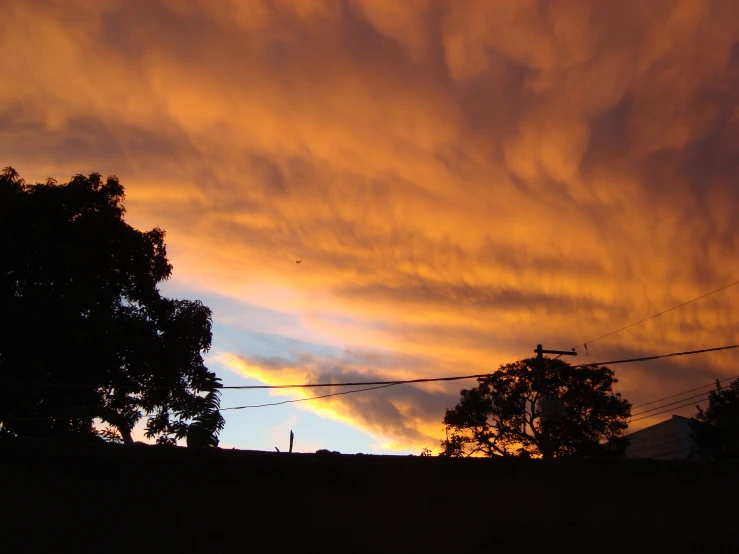 the sky is cloudy in a very orange sunset