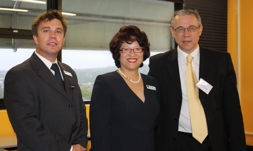 two men and a woman stand near each other