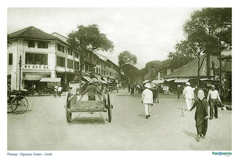 people are walking on a street with many buildings