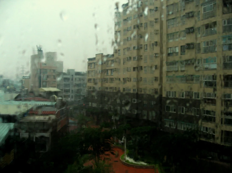 buildings outside a rainy window with raindrops