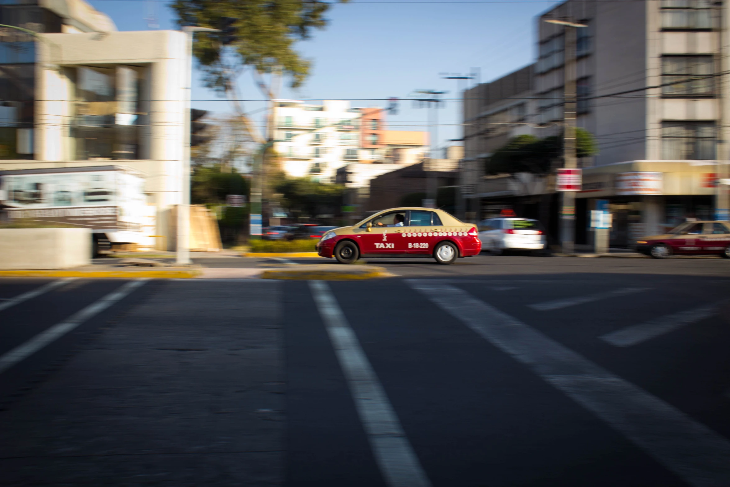 small, compact car sitting at an intersection on a sunny day