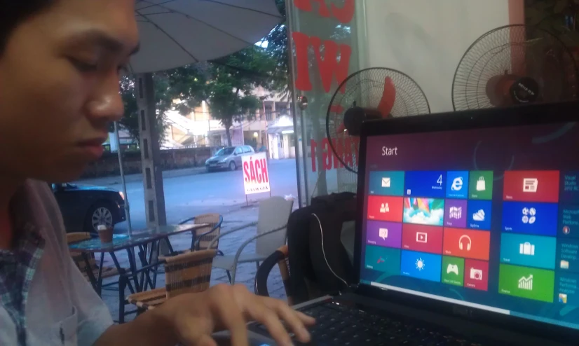 a man in front of a laptop using his hands to connect with the screen