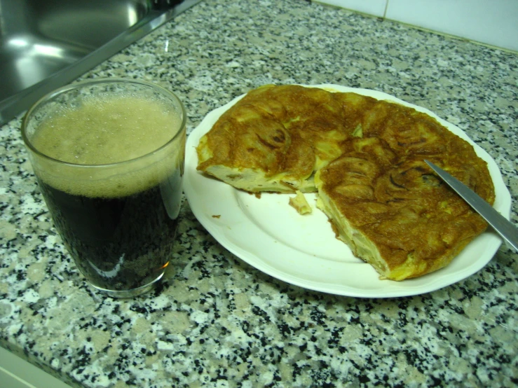 a plate that has a sandwich and a drink on a table