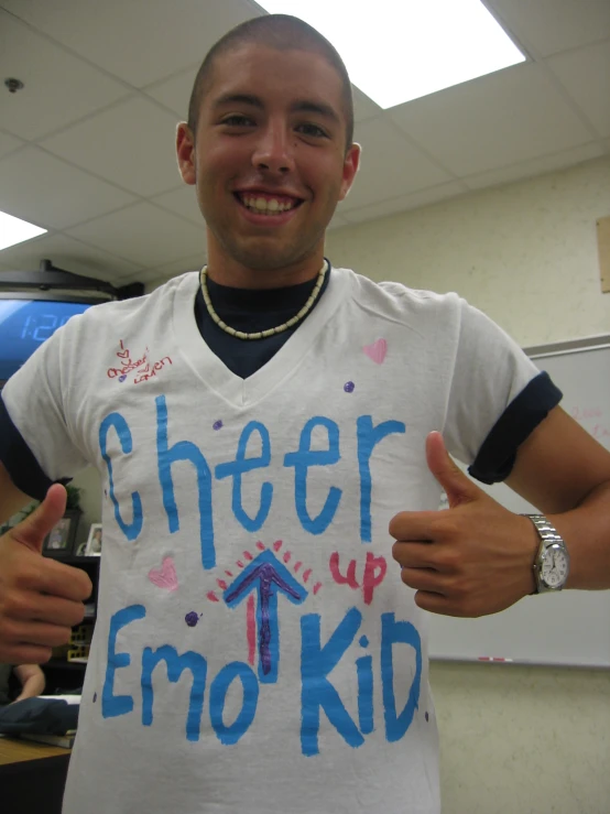 a person is holding up an t - shirt with a blue writing on it