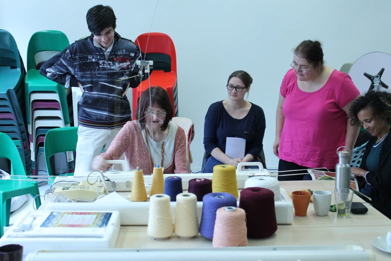 a group of people standing around a table making soing