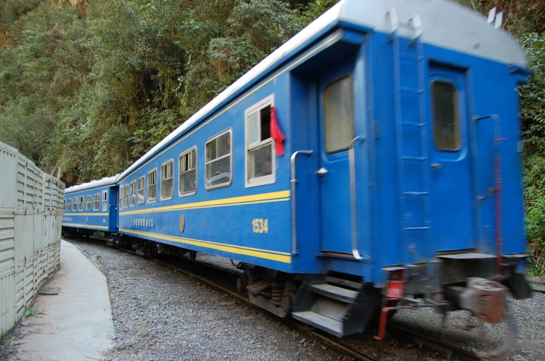 there is a blue train parked on the tracks