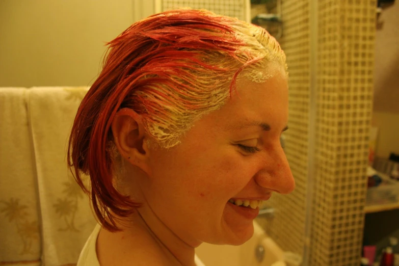 a woman with red hair standing in front of a sink