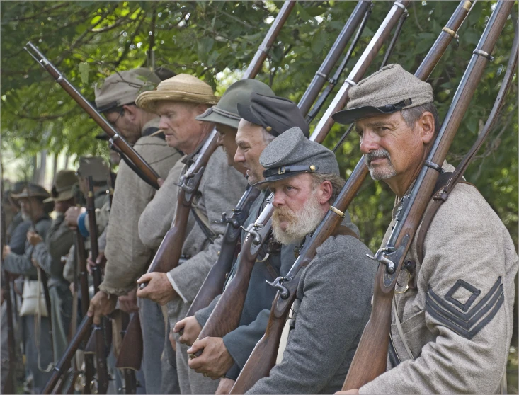 several men are holding guns and posing for a po