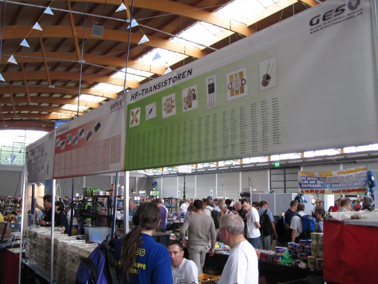 a large crowd of people are standing around a vendor