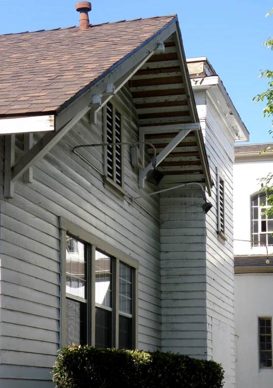 a gray two story house with brown roofs and white trim
