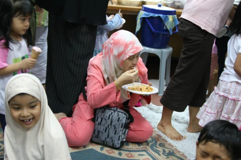 a group of children who are sitting down eating food