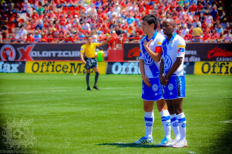 two men in uniforms on a field next to each other