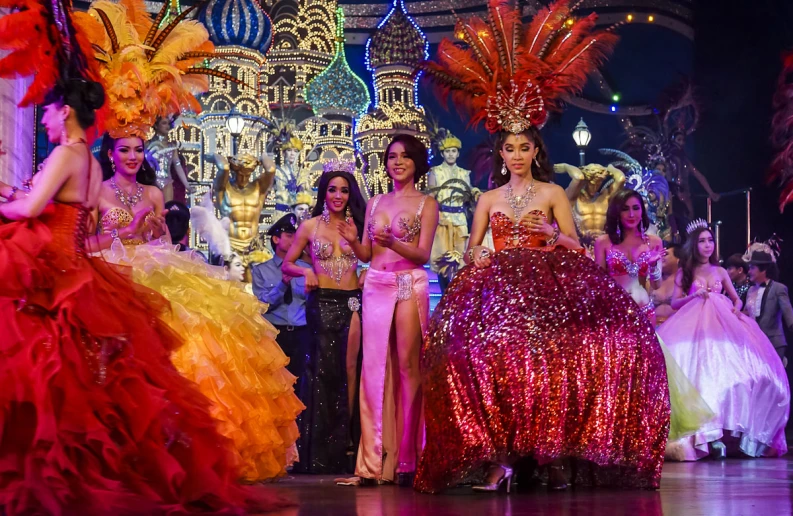 women in dresses standing on stage while others stand nearby