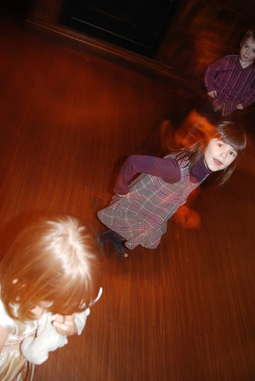 two little girls that are sitting on a floor