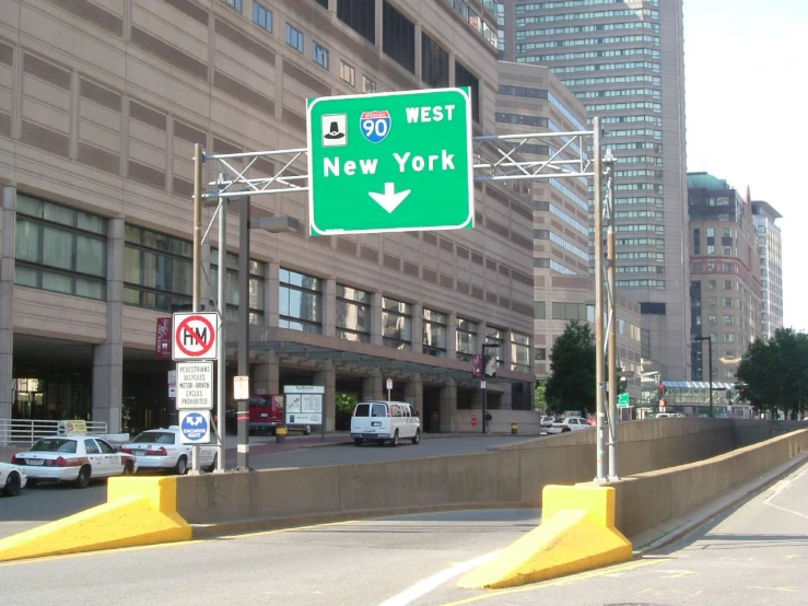 an exit sign next to an intersection in a large city