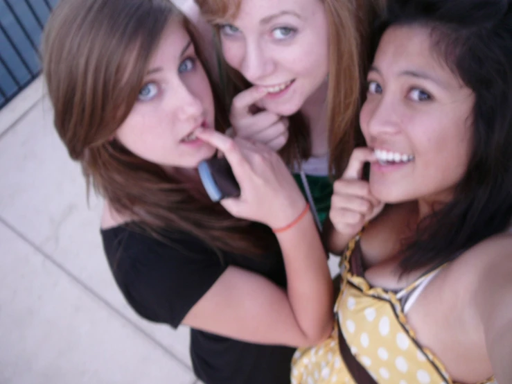 a group of three girls standing next to each other