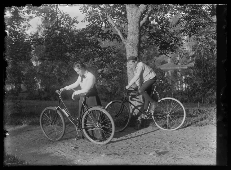 two people sitting on the back of bicycles